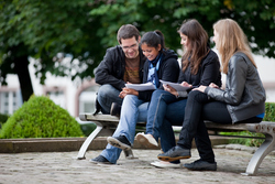 Students sitting on a bench outside at the Gengenbach campus