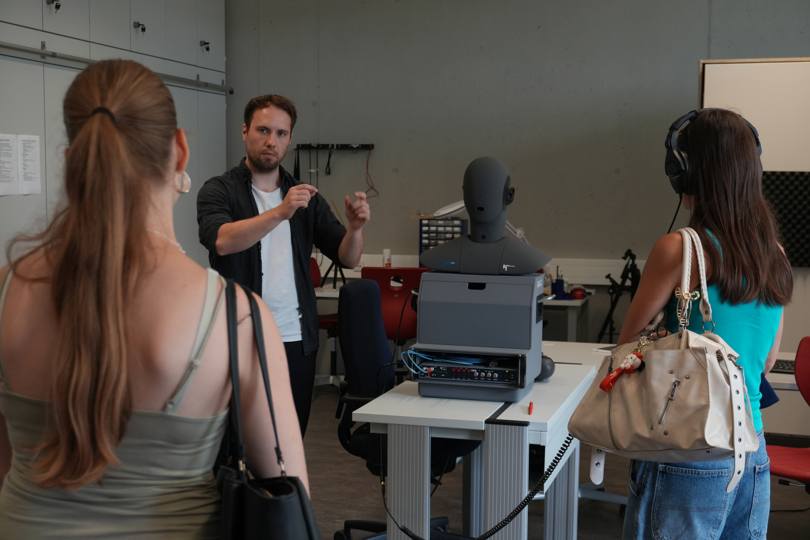 Ein Mann erklärt drei Mädchen etwas an einem Styroporkopf